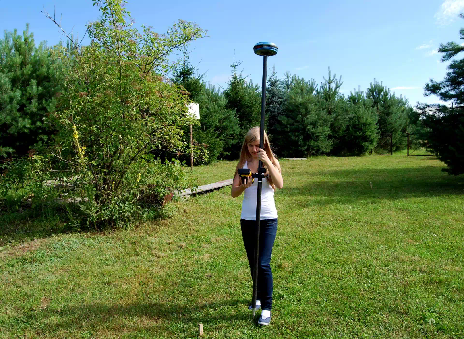 kobieta trzymająca statyw geodety